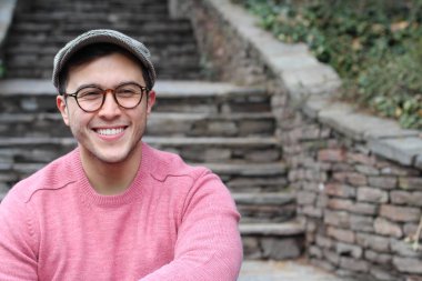 Şehir caddesinde sıradan kıyafetler giymiş yakışıklı bir gencin yakın plan portresi.