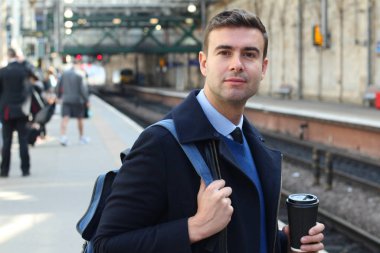 İş adamı retro tren istasyonunda yürüyor