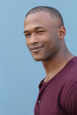 Mavi duvarın önündeki yakışıklı Afro-Amerikan 'ın yakın plan portresi.