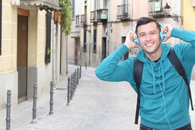 Genç etnik adam dışarıda teknoloji kullanıyor.