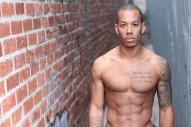 Yakışıklı, üstsüz, Afro-Amerikan bir adamın sokakta çekilmiş yakın plan portresi.