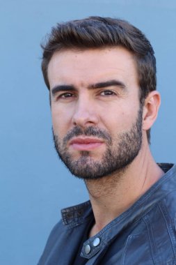 Duvarın önündeki yakışıklı sakallı adamın yakın plan portresi.