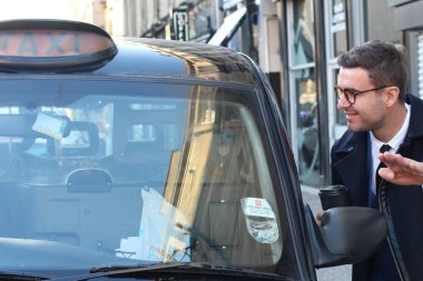 Sokakta taksiye binen yakışıklı genç adamın yakın plan portresi.