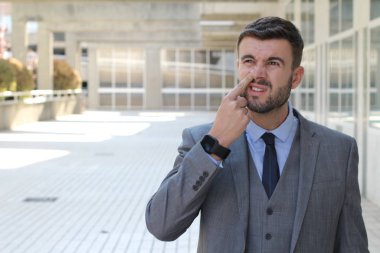 Sokakta gri takım elbiseli yakışıklı genç işadamının yakın plan portresi.