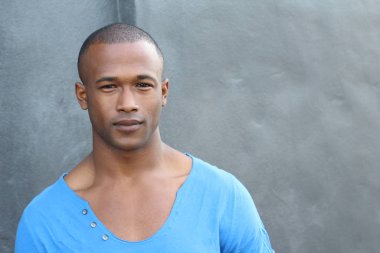 Sokakta mavi tişörtlü yakışıklı Afro-Amerikan adamın yakın plan portresi.