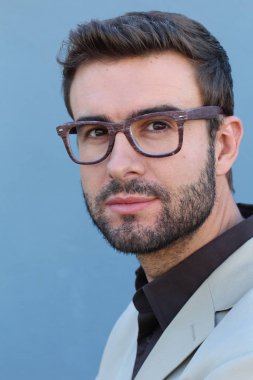Duvarın önündeki yakışıklı sakallı adamın yakın plan portresi.