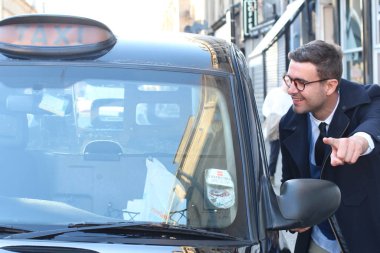 Sokakta taksiye binen yakışıklı genç adamın yakın plan portresi.