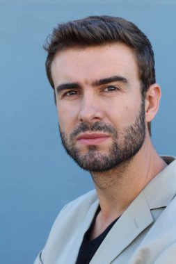 Duvarın önündeki yakışıklı sakallı adamın yakın plan portresi.