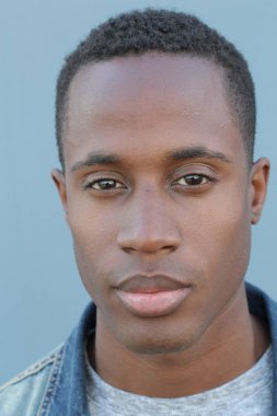 Mavi duvarın önündeki yakışıklı Afro-Amerikan 'ın yakın plan portresi.