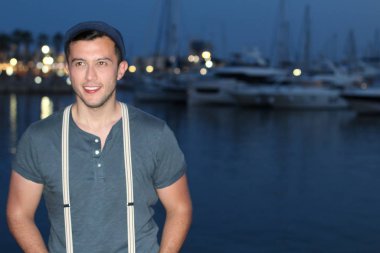 Akşamları limandaki yakışıklı genç adamın yakın plan portresi.