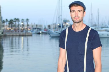 Limandaki yatların önündeki yakışıklı genç adamın yakın plan portresi.