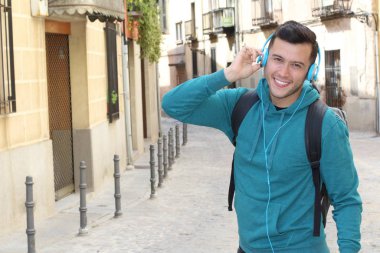 Genç etnik adam dışarıda teknoloji kullanıyor.