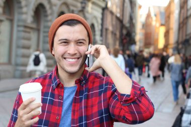 close-up portrait of handsome young man talking by phone on street