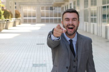 Sokakta gri takım elbiseli yakışıklı genç işadamının yakın plan portresi.