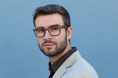 Duvarın önündeki yakışıklı sakallı adamın yakın plan portresi.