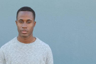 Mavi duvarın önündeki yakışıklı Afro-Amerikan 'ın yakın plan portresi.