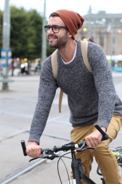 Şehirde bisiklet süren şık bir adam.