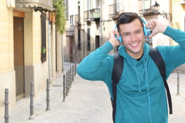 Genç etnik adam dışarıda teknoloji kullanıyor.