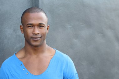 Sokakta mavi tişörtlü yakışıklı Afro-Amerikan adamın yakın plan portresi.