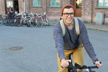 Şehirde bisiklet süren şık bir etnik adam.