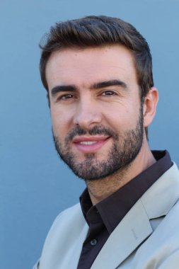 Duvarın önündeki yakışıklı sakallı adamın yakın plan portresi.