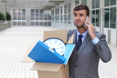 Depresyondaki işadamı eşyalarını taşıyor.