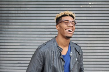 Duvarın önündeki deri ceketli yakışıklı genç adamın yakın plan portresi.