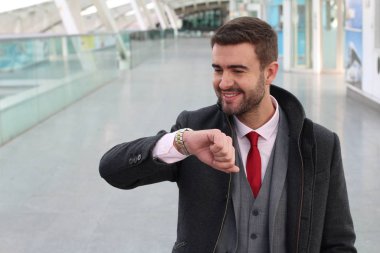 Delikanlı tren istasyonunda durup saatlere bakıyor. 