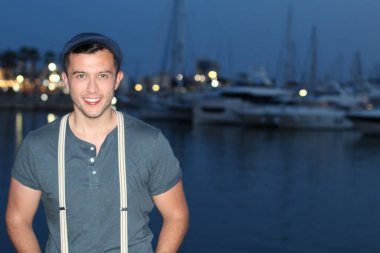 Akşamları limandaki yakışıklı genç adamın yakın plan portresi.