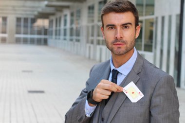 Yakışıklı genç iş adamının yakın plan portresi. Elinde kupa ası var.