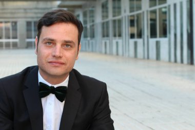 Siyah takım elbiseli, papyonlu yakışıklı bir gencin yakın plan portresi.