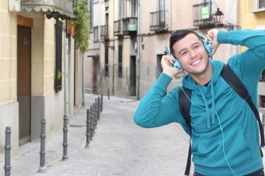 Genç etnik adam dışarıda teknoloji kullanıyor.