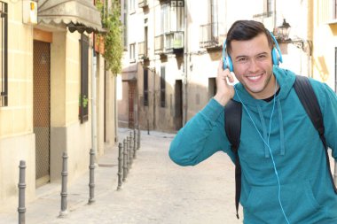 Genç etnik adam dışarıda teknoloji kullanıyor.