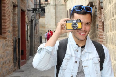 Klasik kamerayla fotoğraf çekmek için yaratıcılığını kullanan bir adam.