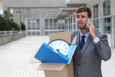 Depresyondaki işadamı eşyalarını taşıyor.