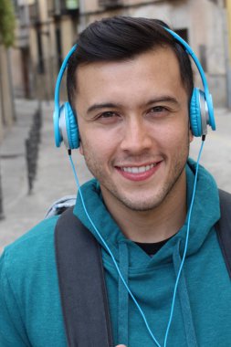 Genç etnik adam dışarıda teknoloji kullanıyor.