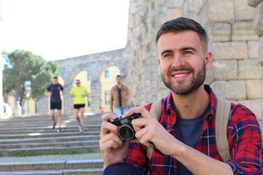 Yakışıklı bir gencin klasik bir kamerayla fotoğraf çektiği yakın plan portresi.