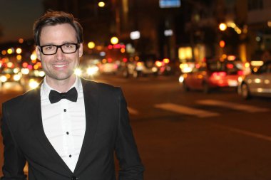 smokinli ve papyonlu yakışıklı bir delikanlının akşam vakti şehir caddesinde yakın plan fotoğrafı.