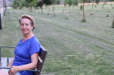 parkta gülümseyen güzel yaşlı bir kadın portresi