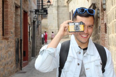 Klasik kamerayla fotoğraf çekmek için yaratıcılığını kullanan bir adam.