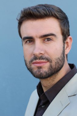 Duvarın önündeki yakışıklı sakallı adamın yakın plan portresi.