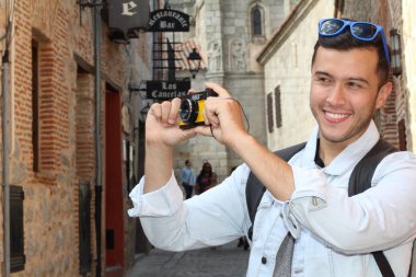 Klasik kamerayla fotoğraf çekmek için yaratıcılığını kullanan bir adam.