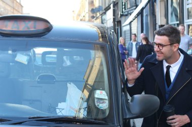 Sokakta taksiye binen yakışıklı genç adamın yakın plan portresi.