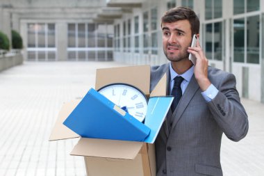 Depresyondaki işadamı eşyalarını taşıyor.