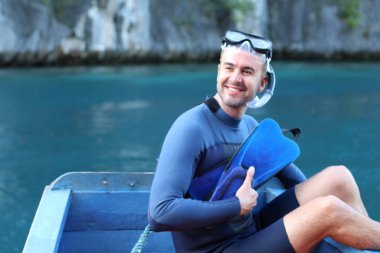 Teknede şnorkel ve maskeli yakışıklı genç adamın yakın plan portresi.