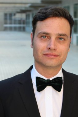 Siyah takım elbiseli, papyonlu yakışıklı bir gencin yakın plan portresi.