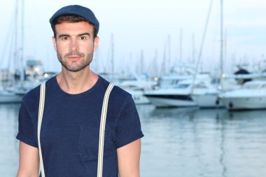 Limandaki yatların önündeki yakışıklı genç adamın yakın plan portresi.
