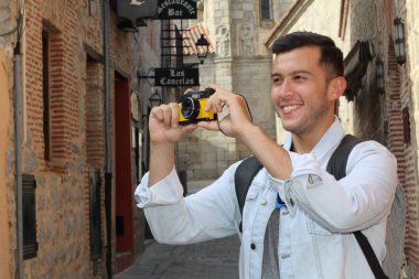 Klasik kamerayla fotoğraf çekmek için yaratıcılığını kullanan bir adam.