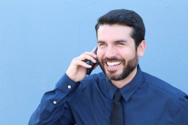 Mutlu iş adamı telefonda mavi stüdyo hakkında konuşuyor.  