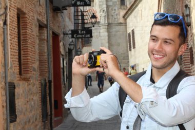 Klasik kamerayla fotoğraf çekmek için yaratıcılığını kullanan bir adam.